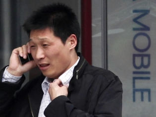 A man talks on his mobile phone in front of a China Mobile shop in central Beijing China smartphone sales 2012