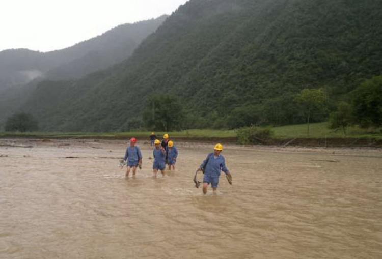 Communist Youth League volunteers wade across a flooded area in rural China (promotional)