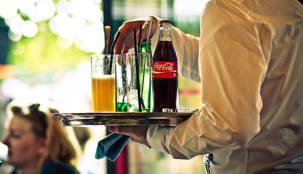 Waiter serving drinks at restaurant