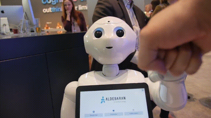 Pepper fist bumping a conference attendee. 