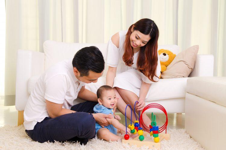 Asian parent playing with their six months old baby boy