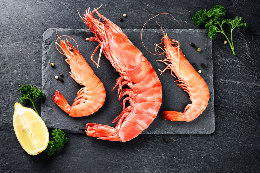 Fine selection of jumbo shrimps for dinner on stone plate. Food background